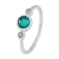 Rina green trilogy ring with a central green gemstone and two smaller clear stones on silver band