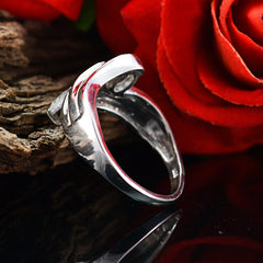 Yasmine silver ring showcasing elegant design reflecting light with red roses background light green trilogy ring
