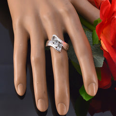 Yasmine silver light green trilogy ring displayed on a mannequin hand with red flowers
