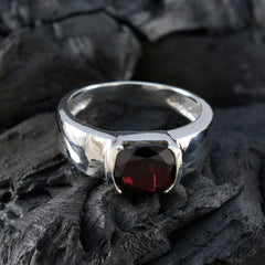 Saanvi luxurious red solitaire ring with deep garnet center in polished silver band on dark textured stone