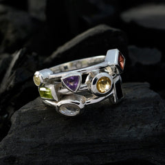 Savannah multicolor cocktail ring with various gemstone shapes set in silver band on dark background