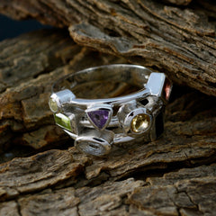 Savannah multicolor cocktail ring with various gemstones set in silver band on rustic wood background
