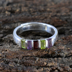 Jia sterling silver band with five baguette stones in green purple and red multicolor gemstone ring on bark background