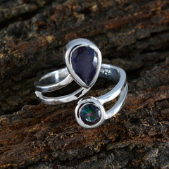 Hazel sterling silver multicolor toi et moi ring with pear shaped blue stone and round iridescent mystic stone on bark