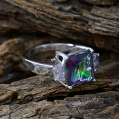Laura multicolor trilogy ring with a square multicolored center stone and silver band on wood