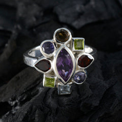 Pilar navratna cocktail ring with multicolored gemstones set in silver band on dark textured background