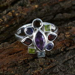 Pilar navratna cocktail ring with multicolored gemstones set in silver band on textured wood