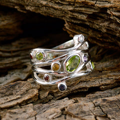 Natcha silver multi gemstone ring with oval green peridot and small colored stones on wood purple gemstone statement ring