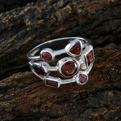 Bianca silver cluster red gemstone statement ring featuring mixed cut red stones on a rustic bark background