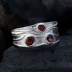 Penelope red gemstone trilogy ring with three round red stones set in textured silver band