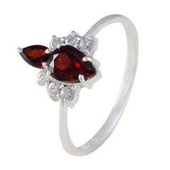 Isabelle red toi et moi ring with two pear shaped red gemstones and halo of small white diamonds on a silver band