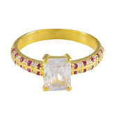 Camila gold ring with romantic red gemstone ring accents and a large clear rectangular center stone