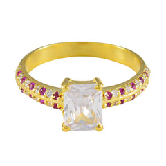 Camila gold ring with romantic red gemstone ring accents and a large clear rectangular center stone