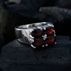 Harper trendy red gemstone ring with four red stones set in a silver band on black background
