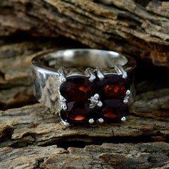 Harper trendy red gemstone ring with four red stones set in silver band on rustic wood