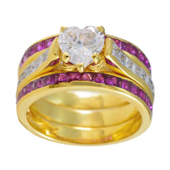Isadora gold band ring with heart shaped clear center stone and channel ruby accents trendy red gemstone ring