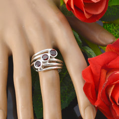 Greta trendy red gemstone trilogy ring silver multi band with three round red stones on mannequin hand with red roses