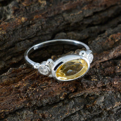 Hana yellow gemstone trilogy ring sterling silver with oval yellow stone and two small accent diamonds on wood