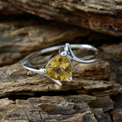 Riya yellow solitaire ring with triangular yellow gemstone set in silver band on rustic wood
