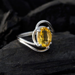 Saanvi yellow solitaire ring with oval yellow gemstone set in silver band on dark background