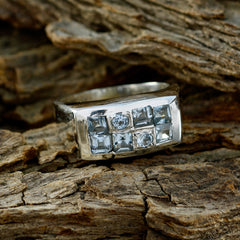 Lakshmi blue gemstone ring silver band with square aquamarine stones and two round accents on wood