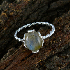 Lakshmi solitaire grey ring with twisted silver band and oval grey gemstone on textured bark