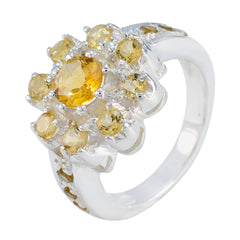 Lakshmi yellow gemstone ring featuring a central oval yellow stone surrounded by smaller yellow gemstones on a silver band