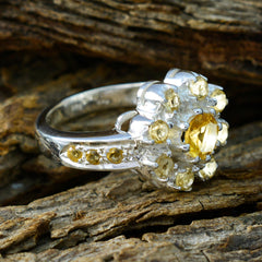 Lakshmi yellow gemstone ring with silver band and multiple yellow stones on rustic wood background
