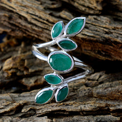 Luna leafy gemstone statement ring with green stones set in silver on textured wood background