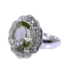 Natcha light green halo ring featuring a large oval green gemstone surrounded by small clear stones