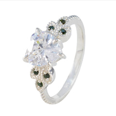 Penelope luxurious green gemstone ring with a large clear round center stone and green accent stones on a silver band