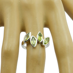 Natcha luxurious green gemstone ring with four marquise peridot stones set in sterling silver band on mannequin hand