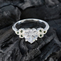 Penelope silver ring with heart shaped clear center stone and side emerald accents luxurious green gemstone ring