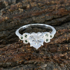 Penelope silver ring with heart cut center crystal and milgrain floral sides set with small emeralds luxurious green gemstone ring