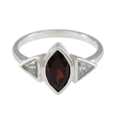 Emi ring featuring a luxurious red gemstone ring with two clear triangular side stones in silver setting