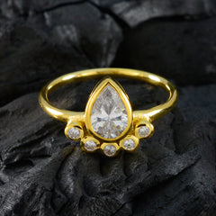 Ji-eun luxurious white gemstone ring with pear-shaped center stone and gold band on dark textured background