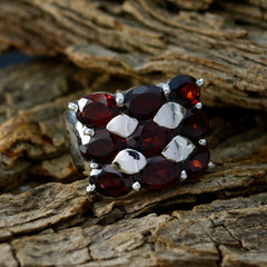 Mathilde Heritage Red Navratna ring cluster of deep garnet red gemstones in polished silver band on rustic wood background