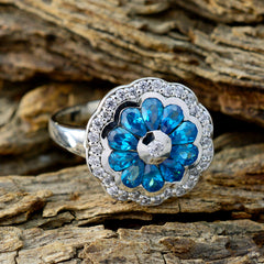Noelia modern blue gemstone ring with floral design and silver accents on rustic wood background