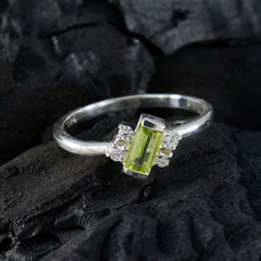Saanvi modern green gemstone ring with rectangular green stone and silver band on dark textured background
