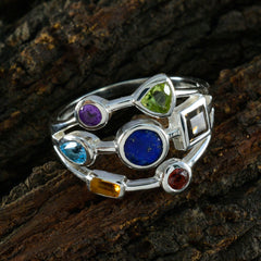 Camila modern multicolor gemstone ring with silver band and various colorful stones on textured bark