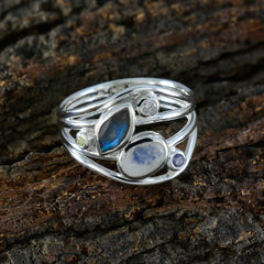Leah modern multicolor gemstone ring with silver band and various colorful stones on rustic wood