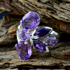 Ayesha modern purple gemstone ring featuring multiple faceted purple stones set in silver on a wooden background