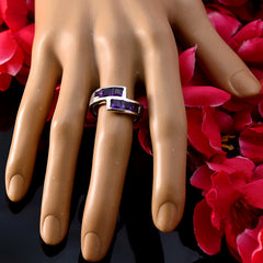 Elena modern purple gemstone ring with rectangular stones on a display hand surrounded by red flowers