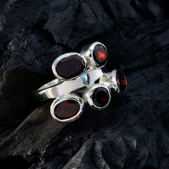 Teresa modern red gemstone ring with multiple red stones set in silver band on dark textured background