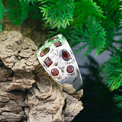 Laura modern red gemstone ring with multiple red stones set in silver band on natural wood background
