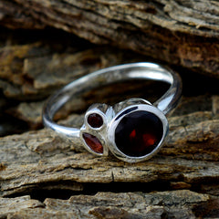 Mei sterling silver modern red gemstone trilogy ring with large round center and two smaller side stones on a slim band