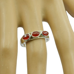 Hana modern red trilogy ring sterling silver band with three red cabochon stones on a display hand