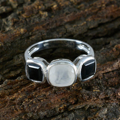 Ines modern trilogy ring with one white center stone and two black side stones on silver band