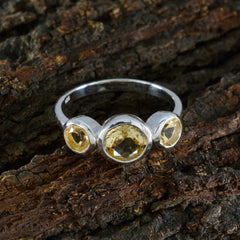 Lili modern yellow gemstone ring with three faceted yellow stones set in silver band on bark background