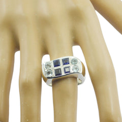 Scarlett multicolor gemstone cocktail ring with blue and clear stones on silver band worn on finger